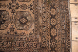 Distressed vintage Afghan rug with camel gold, brown triple gul motifs and geometric borders.