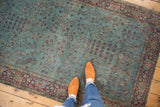Distressed aqua blue field of an antique Kerman rug, featuring delicate burgundy vinery and visible knot heads.