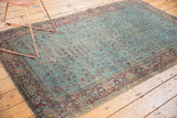 Kerman rug detail: distressed aqua field, burgundy vinery, and visible historic even wear.