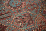 Distressed Baktiari carpet detail: low pile, multi-paneled motif with dusty blue, wine red, and copper tones.