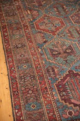 Low pile distressed vintage Baktiari carpet, showing geometric motif in dusty blue and red.