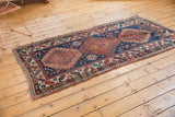 Worn antique Kazak runner: hook-and-latch medallions, navy blue field, cherry red patterns.
