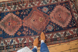 Antique Kazak runner: central geometric medallions, serpent designs, navy, madder root, and wear.