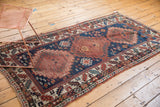 Geometric ivory, red, and navy border with the secure side cord selvage of an antique Kazak runner.