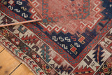 Antique Kazak runner corner with madder red field, hook motifs, and geometric borders.