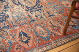 Textured pile of antique Soumac rug featuring large-scale brick red and navy motifs.