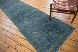 Distressed Hamadan runner featuring faded blue overdye tones and subtle palmette motifs.