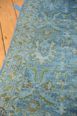 Distressed Hamadan runner's low pile, featuring faded denim blue and green palmette motifs.