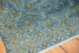 Distressed Hamadan runner corner with fringe, showcasing faded blue tones and worn low pile.