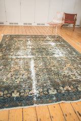 Distressed Hamadan rug corner showing blue border, camel field, and exposed foundation.