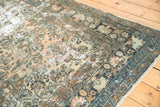Distressed vintage Hamadan rug detail: exposed foundation highlights floral patterns in camel, seafoam blue.