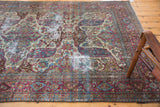 Distressed Baktiari carpet's curvilinear Safavid-inspired design with violet, ivory, and blue tones.