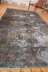 Vintage distressed Baktiari carpet with curvilinear violet, blue, ivory patterns and visible foundation.