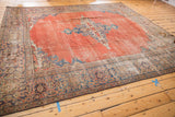 Antique Mahal carpet border shows intricate blue and purple motifs on madder red with wear.