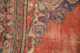 Detail of antique Mahal carpet corner: madder root red field, even wear, faded purple curvilinear spandrel.