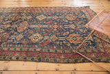 Hand-woven antique Soumac carpet showcasing its geometric pattern and vibrant red border.