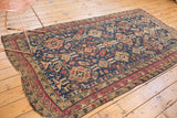 Antique Soumac carpet featuring navy, cherry red, and ivory geometric floral motifs.