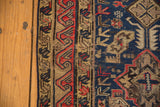 Antique Soumac carpet's secured side selvage and geometric border with navy and cherry red.