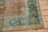 Distressed vintage Agra rug corner, sky blue serrated leaf border, worn pale coffee field.