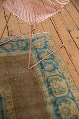 Distressed vintage Agra rug showing worn bronze field and sky blue serrated leaf border.