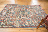 Distressed Heriz rug corner, highlighting ivory, sky blue, faded red patterns, and soft texture.