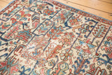 Distressed vintage Heriz fragment, faded red and blue patterns, visible wear to knot heads.