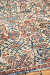 Worn Heriz geometric patterns in ivory, denim blue, and faded red with exposed foundation.
