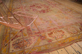 Faded oversized patterns on a vintage Oushak rug, saffron, blush, ivory, cherry red.