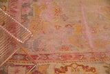 Worn texture and curvilinear motifs in blush, saffron, and silver on vintage Oushak.