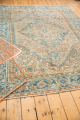 Rectilinear geometric patterns in soft blue and pale camel on a distressed vintage Heriz carpet.