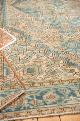 Textured pile of the distressed Heriz rug, rectilinear geometric patterns in pale camel and ocean blue.