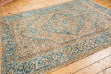 Corner detail of vintage distressed Heriz carpet, showing knot head wear with blue and ivory rectilinear patterns.