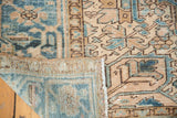 Corner of distressed Heriz carpet showing secure selvage, geometric pattern, and hand-knotted reverse.