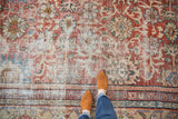Distressed antique Mahal carpet with madder red field, oversized floral palmettes, and ornate border details.