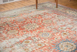 Distressed madder red field, low pile texture, and faded floral palmettes.