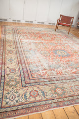 Antique Mahal carpet corner: distressed madder red field, sand-toned borders, floral palmettes.