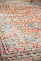 Distressed pile of antique Mahal carpet, revealing faded madder red and sky blue floral palmettes.