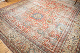 Distressed Antique Mahal rug corner, featuring madder red floral palmettes and intricate sand-toned borders.
