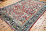 Distressed vintage Mahal rug corner with ruby red field, ivory motifs, and exposed foundation.