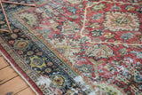 Textured pile of vintage distressed Mahal carpet with ruby red, ivory, blue, and visible foundation.