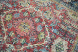Distressed vintage Mahal rug, with brilliant ruby red floral design and visible foundation wear.