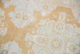 Textured detail of distressed vintage Kayseri rug with faded pale gold saffron and ivory patterns.