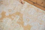 Ornamented paisley botehs and budded flowers in saffron and ivory on distressed Kayseri rug.