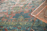 Close-up of distressed Mahal carpet, dusty blush and teal vinery, with scattered foundation showing through.