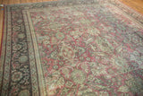 Textured field of distressed Mahal carpet, showing muted floral palmettes in faded red and seafoam.