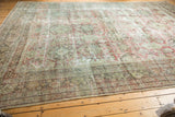 Distressed allover roundel pattern in seafoam green and faded brick red on a vintage Mahal carpet.
