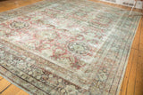 Distressed Mahal rug corner showcasing faded roundel motifs, red, and seafoam green tones.