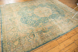Vintage Khorassan rug corner with sky blue-green palmette motifs, camel gold field, and aged texture.