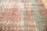 Distressed texture of an antique Malayer runner, showcasing worn terra cotta and blue.