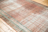 Distressed texture of a Malayer runner, revealing faded terra cotta and cotton white pile.